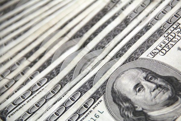 A large stack of $100 bills with Benjamin Franklin on them.