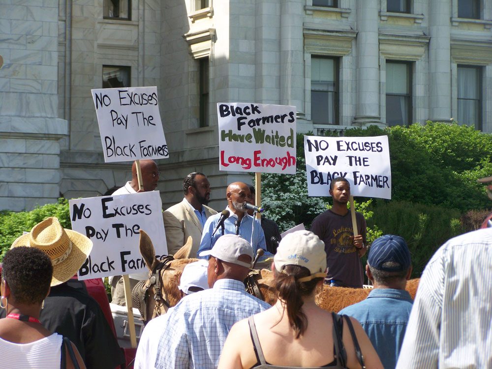 Protestors with signs for the Pigford II Black Farmers case
