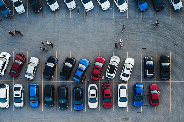 Aerial drone shot of a busy parking lot with cars parked crooked.