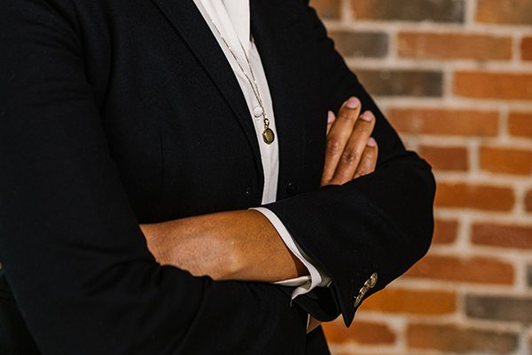 Black woman in business suit with arms crossed