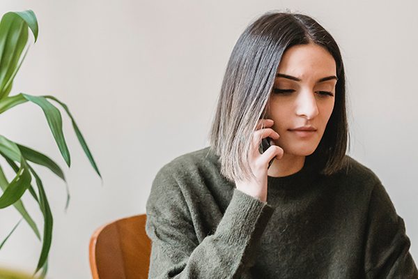 Woman in an apartment talking on her cell phone.