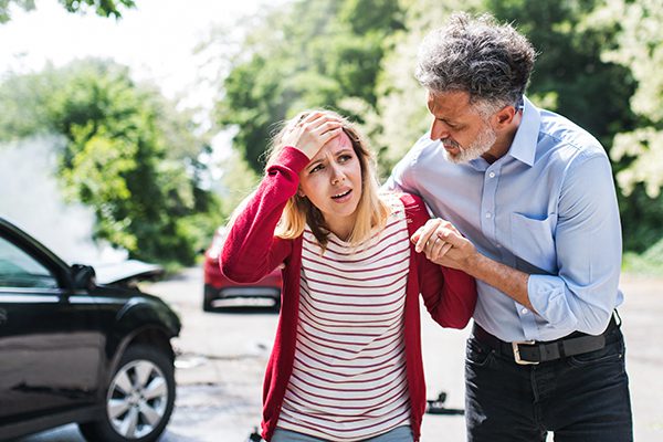 Man comforting a woman after a traumatic car crash