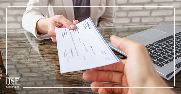 Person being handed a check for their workers' compensation settlement.