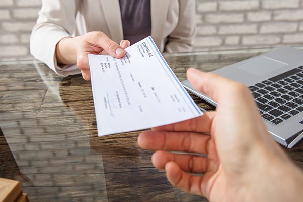 Person being handed a check for their workers' compensation settlement.
