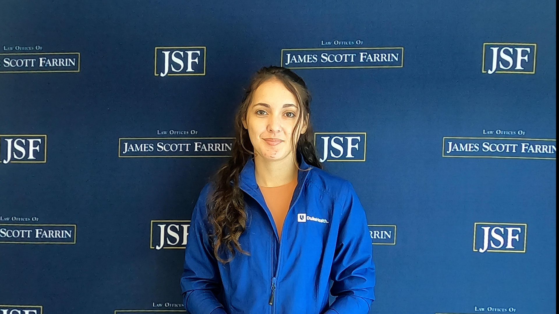 Client standing in front of a blue JSF background.