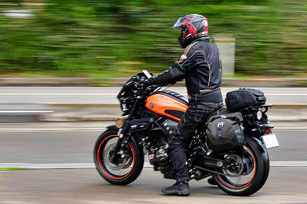 A black and orange motorcycle on a highway.