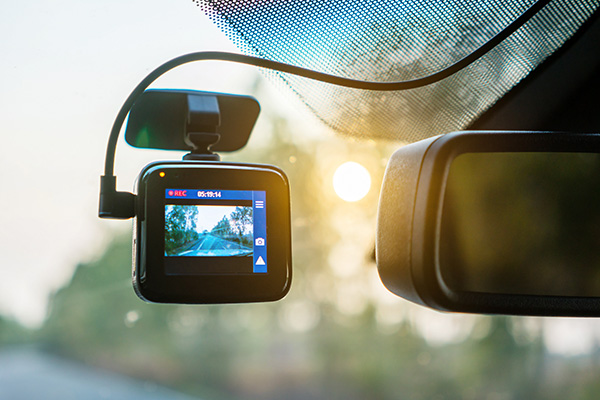 A dash camera mounted to the windshield of a car.