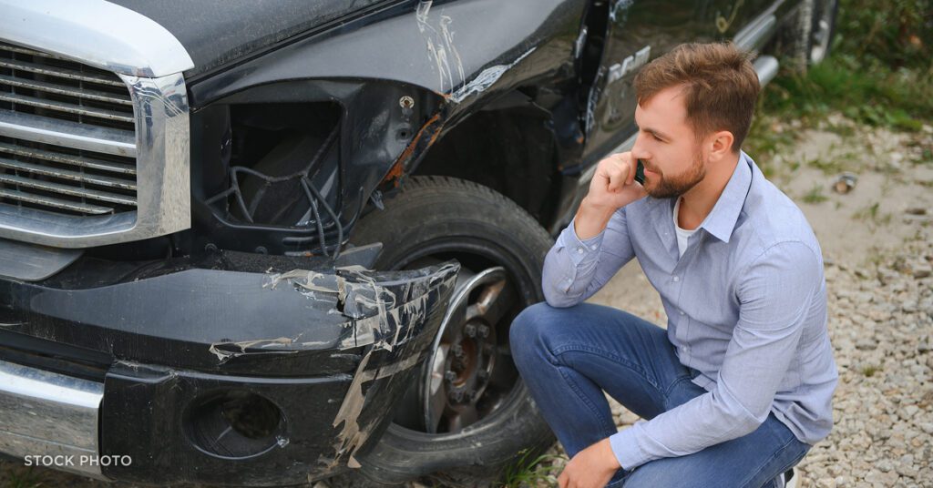 Law Offices of James Scott Farrin, Greensboro, NC hit & run car accident lawyers. Driver inspecting vehicle damage after collision.