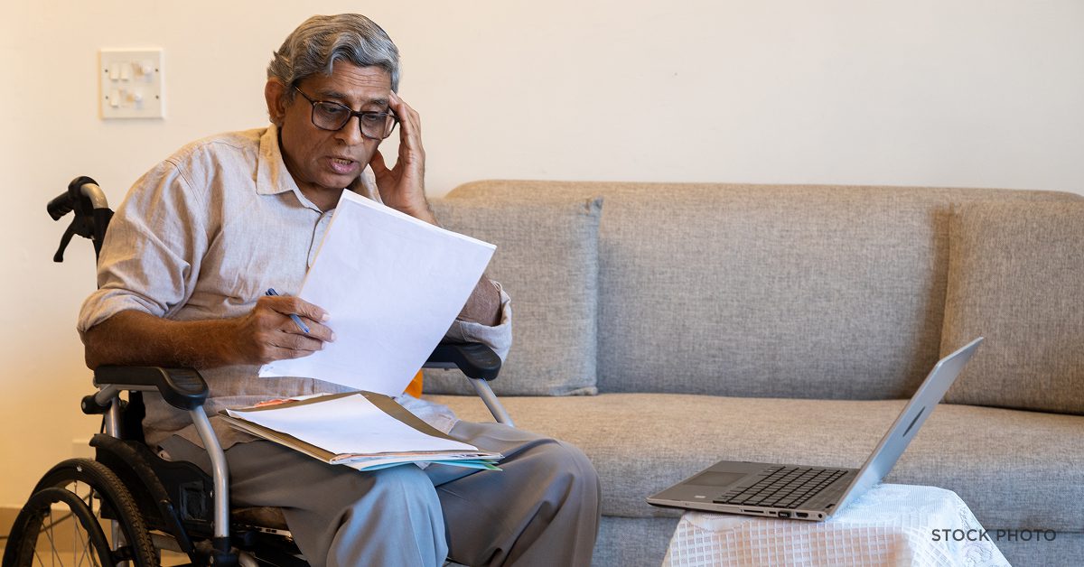 A disabled man in a wheelchair anxious about medical documents. James Scott Farrin, Social Security Disability attorneys.